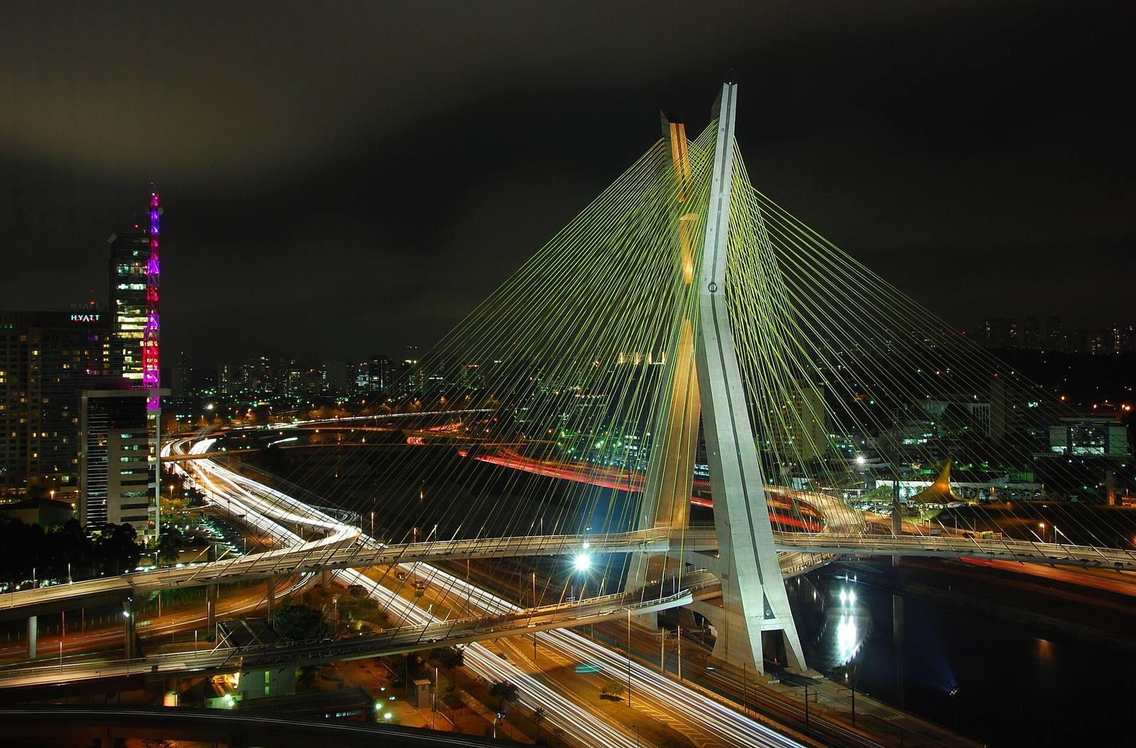 Cidade brasileira conectada à noite, com trilhas de luz nas avenidas